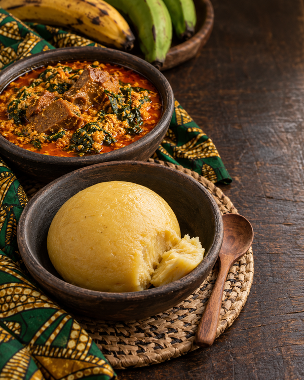 Plantain fufu served with egusi soup in clay bowls