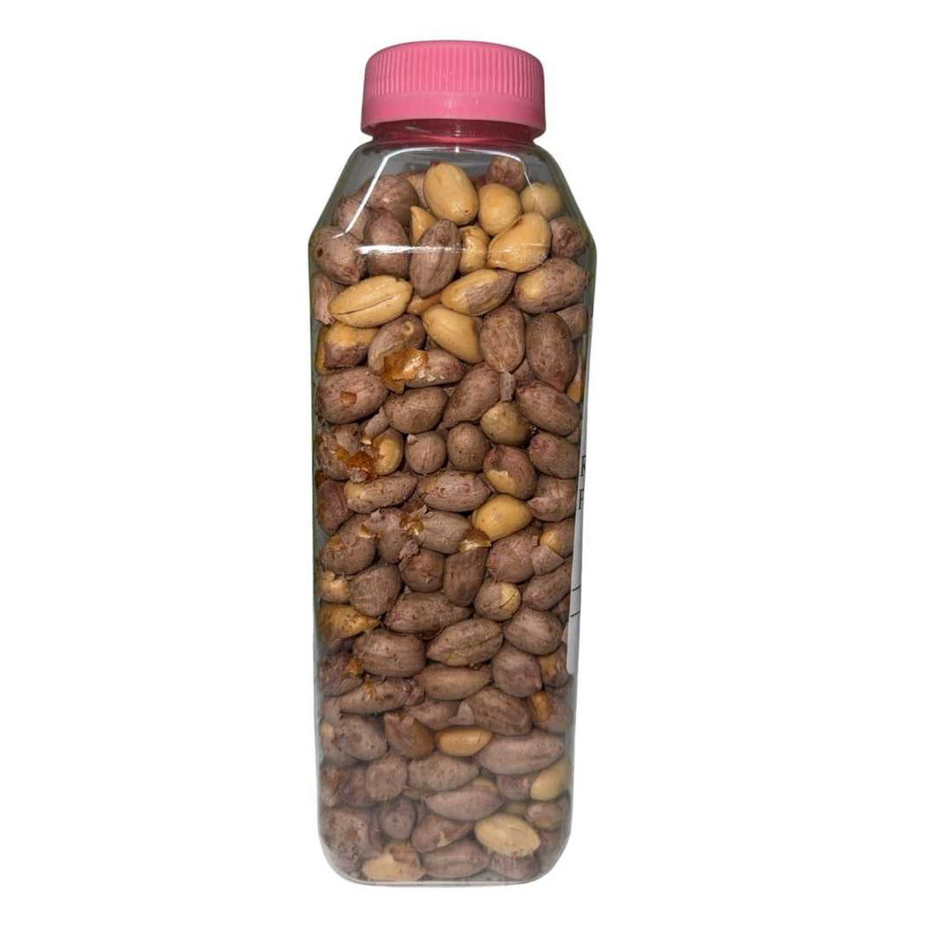 A clear plastic jar with a pink screw cap filled with African roasted peanuts, some still in their skins. The jar has a white label that reads: “AFRICAN ROASTED PEANUT.”