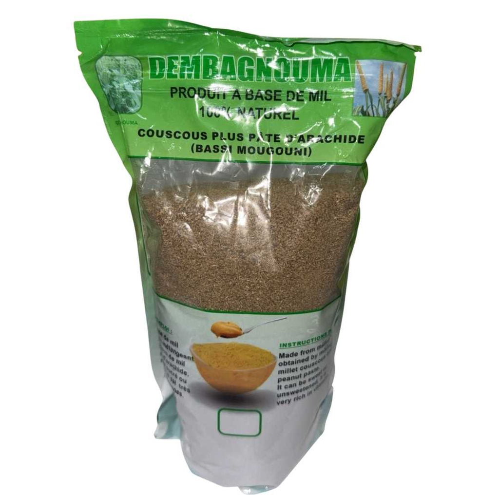 A sealed green and transparent package of DEMBAGNOUMA, a 100% natural millet-based product labeled as 'Couscous plus pâte d’arachide (Bassi Mougouni)'. The front of the package shows a bowl of millet couscous with a spoonful of peanut paste above it, along with instructions and product information in French and English.