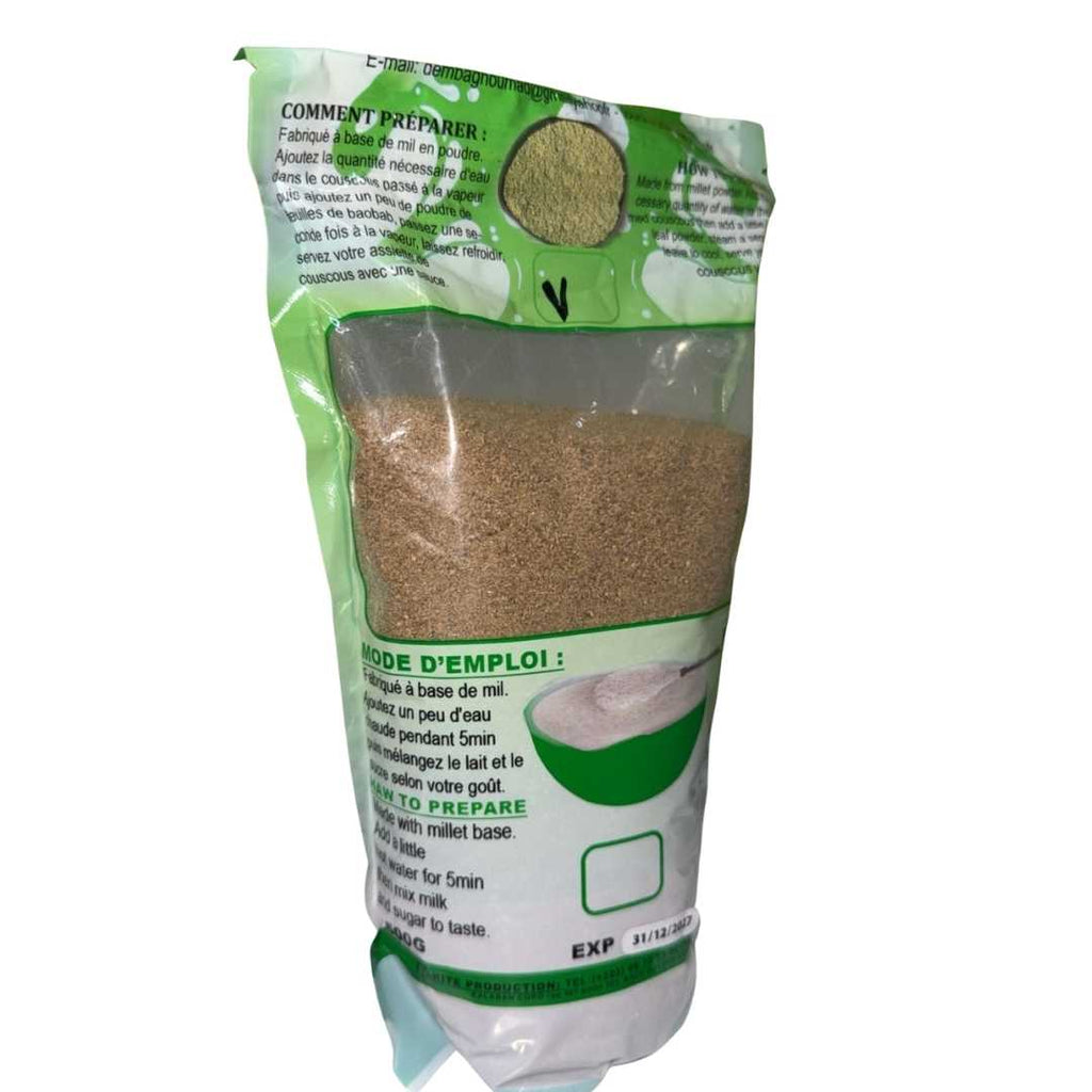 A sealed green and transparent package of DEMBAGNOUMA, a 100% natural millet-based product labeled as 'Couscous plus pâte d’arachide (Bassi Mougouni)'. The front of the package shows a bowl of millet couscous with a spoonful of peanut paste above it, along with instructions and product information in French and English.