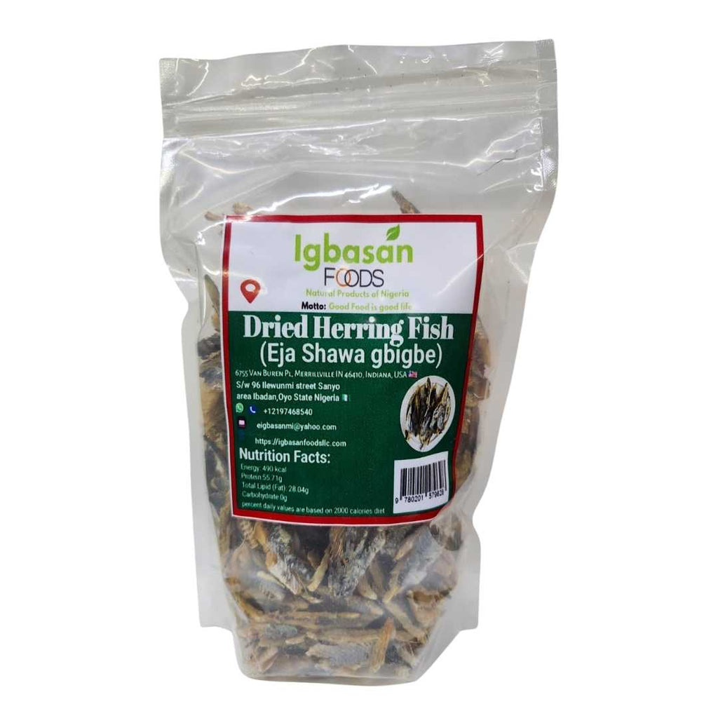 A clear resealable bag of Igbasan Foods Dried Herring Fish (Eja Shawa gbigbe) showing dried fish pieces inside. The front label is green, white, and red, featuring the Igbasan Foods logo, contact information, and nutrition facts.