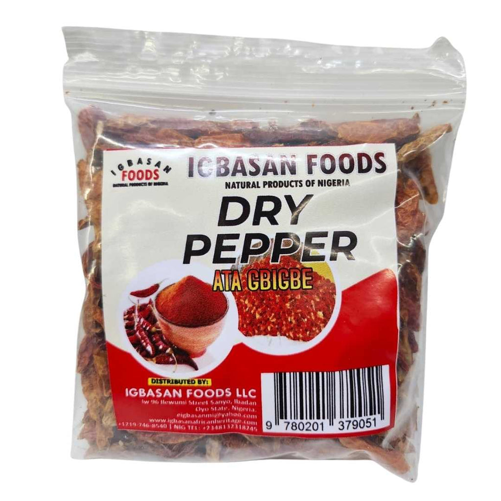 A clear plastic bag of Igbasan Foods Dry Pepper (Ata gbigbe) showing whole dried red chili peppers. The front label is white and red, featuring the Igbasan Foods logo, images of ground pepper, and a barcode.