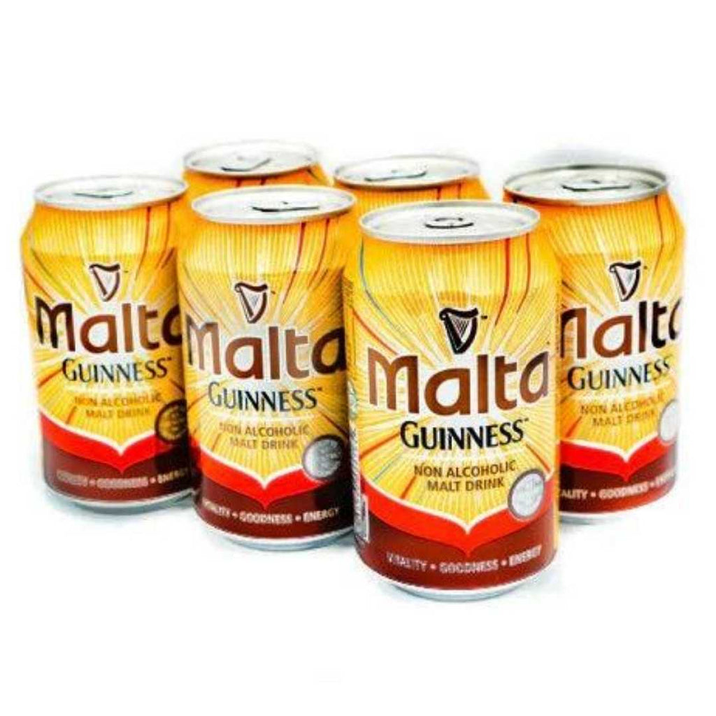 A six-pack of Malta Guinness cans, arranged in a shrink-wrapped bundle. The cans are gold and brown with the Malta Guinness logo prominently displayed.