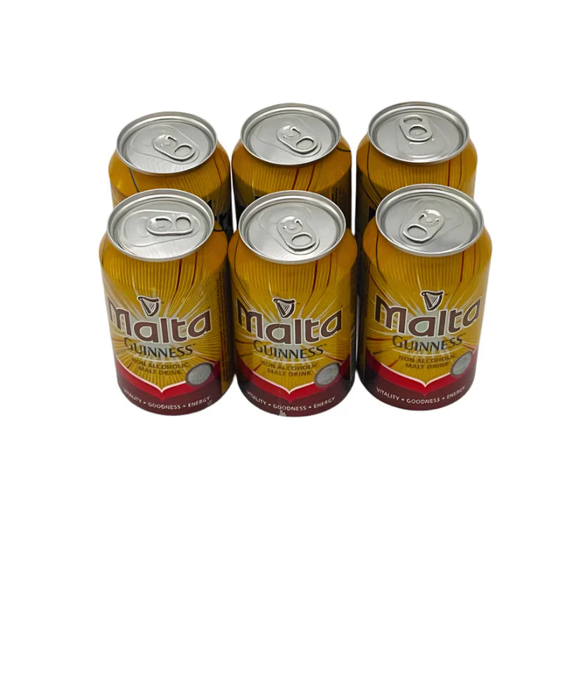 A six-pack of Malta Guinness cans, arranged in a shrink-wrapped bundle. The cans are gold and brown with the Malta Guinness logo prominently displayed.